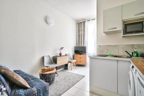 une cuisine et un salon avec un canapé dans l'établissement Magnificent studio near Paris, à Clichy