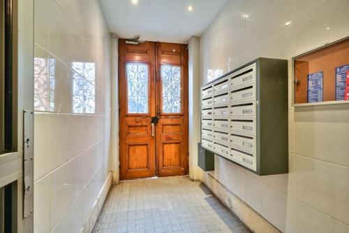 um corredor com uma porta de madeira na casa de banho em Magnificent studio near Paris em Clichy