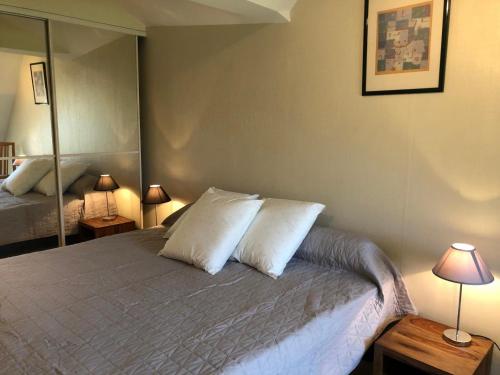 una camera con un letto con due cuscini e due lampade di Rive de gartempe a Vicq-sur-Gartempe