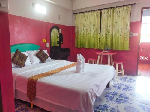 a bedroom with a large bed and a red wall at Sabaydee House at Pai in Pai