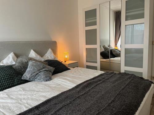 1 dormitorio con 1 cama grande y espejo en Seebrise Velden - only 500 meter from lake!, en Velden am Wörthersee