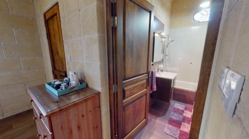 a bathroom with a shower and a wooden door at Qala Bed&Breakfast with swimming pool - IL-Wenniessa in Qala