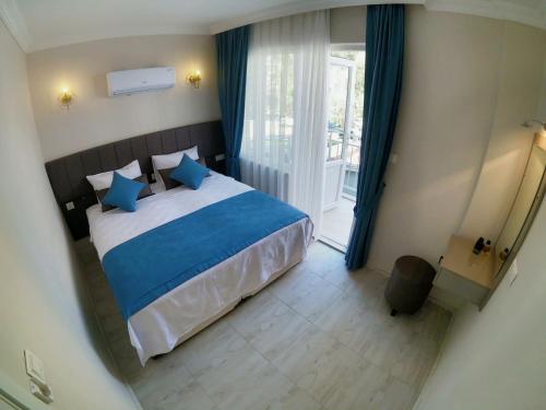 a bedroom with a bed and a large window at MirAlya Homes in Fethiye