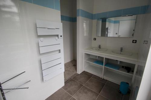 La salle de bains blanche est pourvue d'un lavabo et d'un miroir. dans l'établissement La charmille, 