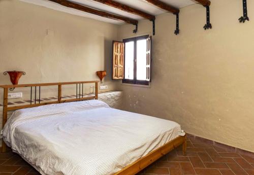 1 dormitorio con cama y ventana en 5 bedrooms villa with private pool furnished terrace and wifi at Benaocaz, en Benaocaz