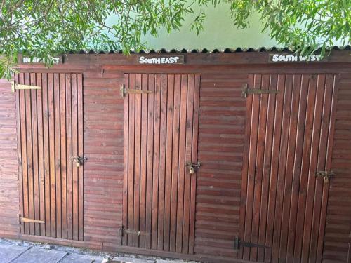 a wooden fence with three wooden doors on it at Cozy Crner, home away from home, near from pristine beaches num2 in Langebaan