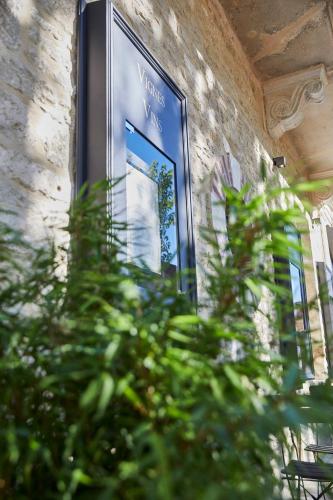 a framed picture on the side of a building with a plant at Olivier Leflaive Hôtel Restaurants in Puligny-Montrachet