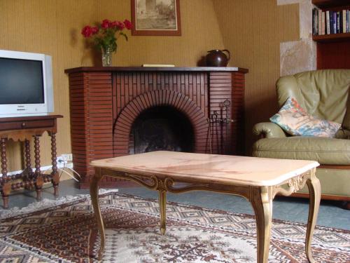 - un salon avec une cheminée et une table basse dans l'établissement La maison du regisseur, à Chauvigny