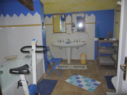 uma casa de banho com um lavatório, um espelho e uma cadeira em Chez l'antoinette em Persac