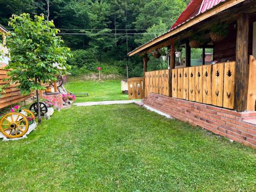 un patio con una casa y una valla de madera en Casa Ele, en Frăsinet