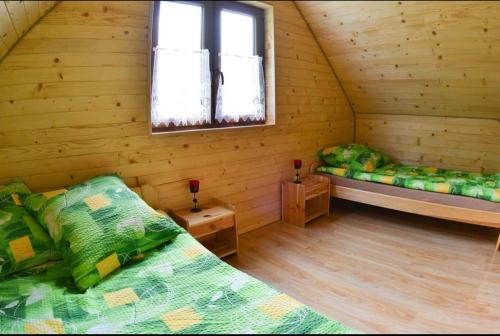 ソリナにあるDOMKI POD CHMURKĄのログキャビン内のベッド2台が備わる部屋です。