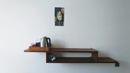 a wooden shelf on a wall with a coffee maker at Thiên Ý Homestay in Phu Quoc