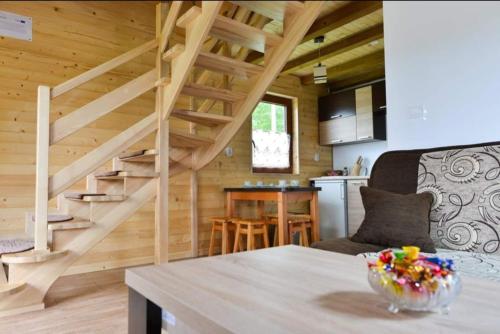 a living room with a staircase in a wooden house at DOMKI POD CHMURKĄ in Solina