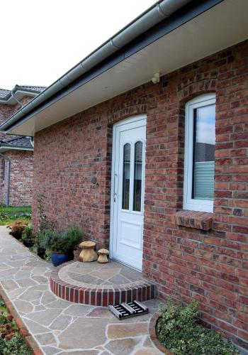 a brick house with a white door and two teddy bears at Scholz-Riewerts - gemütliches Apartment mit Küche für 2 Personen in Silberstedt