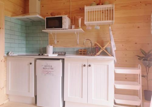 - une cuisine avec un plan de travail, un évier et un four micro-ondes dans l'établissement Le Cottage OneHeart, à Saverne