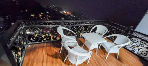 three chairs and a table on a balcony at Casa Arhan 2-3-4-7-12 BHK Luxury Penthouse in Mussoorie