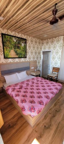 a bedroom with a large bed with a pink blanket at Casa Arhan 2-3-4-7-12 BHK Luxury Penthouse in Mussoorie