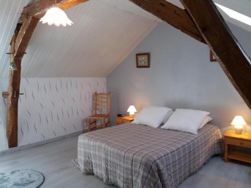 a bedroom with a bed and two tables and a chair at Clé des champs in Antran