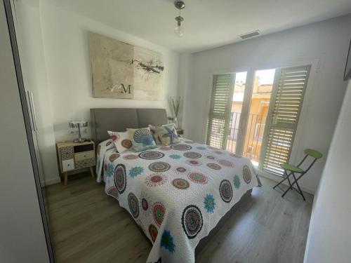 ein Schlafzimmer mit einem Bett mit einer Bettdecke darauf in der Unterkunft ATICO - CANTOS DE SIRENA in Torremolinos