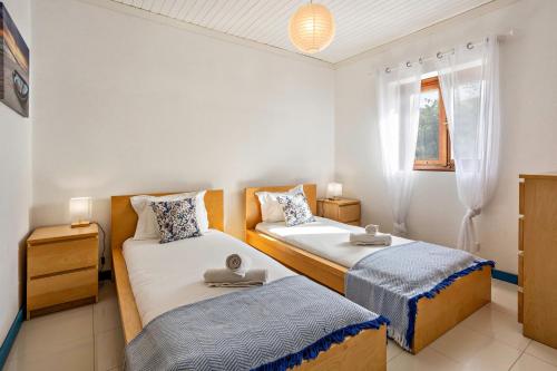 a bedroom with two beds and a window at Casa da Praia in Vila Baleira