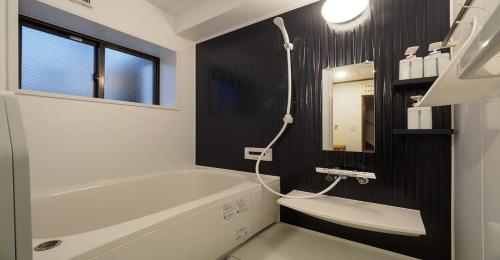 a bathroom with a tub and a sink and a mirror at Kyoto Hostel japanese room 2F / Vacation STAY 8178 in Kyoto