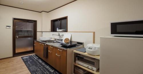a small kitchen with a refrigerator and a tv at Kyoto Hostel japanese room 2F / Vacation STAY 8178 in Kyoto