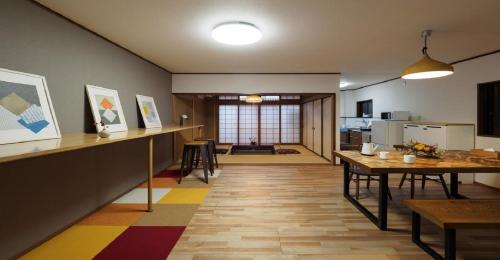 a living room with a table and a kitchen at Kyoto Hostel japanese room 3F / Vacation STAY 8183 in Kyoto