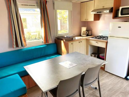 une petite cuisine avec une table et un réfrigérateur dans l'établissement Mobil home 6 personnes PORT LA NOUVELLE, à Port-la-Nouvelle