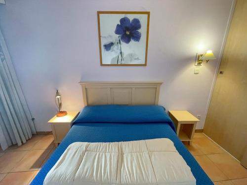 - une chambre dotée d'un lit bleu avec une fleur bleue sur le mur dans l'établissement Blu Home 3 Pers Centrale AC WiFi, à Menton