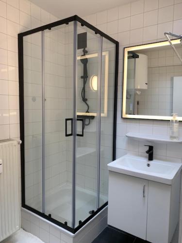 a bathroom with a glass shower and a sink at Appartement Wim in Blankenberge