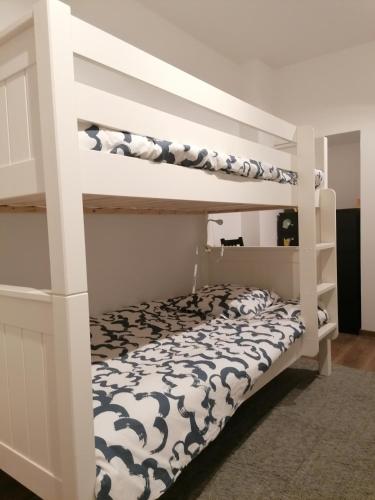 Chez Marylene في Soisy-sur-École: غرفة نوم مع سرير بطابقين ابيض