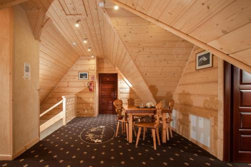 a dining room in a log cabin with a table and chairs at Chochołowskie Zacisze przy Termach - Apartamenty i Pokoje in Chochołów