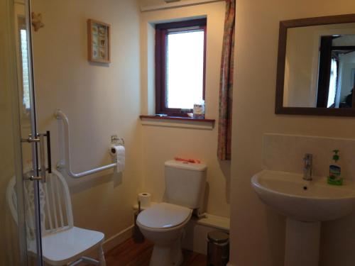 a bathroom with a toilet and a sink at Strathwhillan House in Brodick