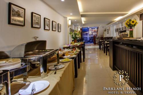 a restaurant with a buffet line with plates of food at Parklane Central Hanoi Hotel in Hanoi