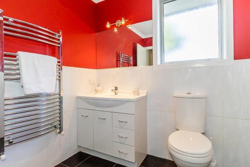 a bathroom with a toilet and a sink and a window at Contemporary Methven Abode in Methven