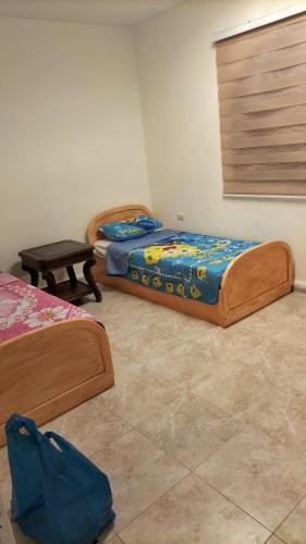 two beds sitting in a room with at SARA HOME 2 in Al Kafrayn