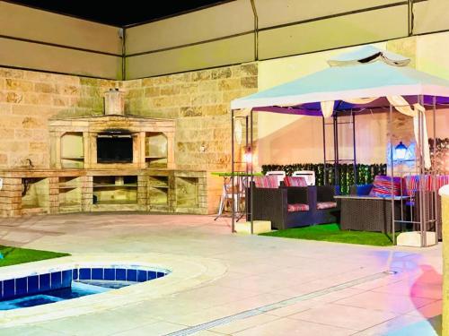 an outdoor patio with an umbrella and an outdoor oven at SARA HOME 2 in Al Kafrayn