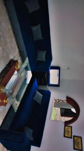 a living room with a blue couch and a table at SARA HOME 2 in Al Kafrayn