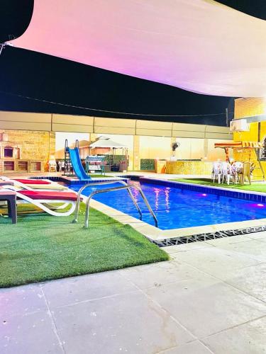 a swimming pool with a slide in the middle at SARA HOME 2 in Al Kafrayn