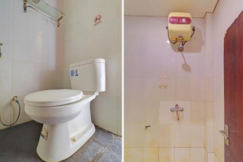 a bathroom with a toilet and a phone on the wall at OYO 92315 Prostay Bali in Denpasar