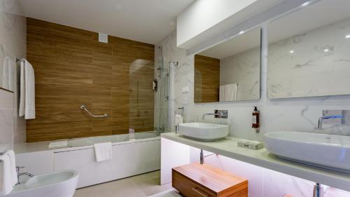a bathroom with two sinks and two mirrors at Quinta do Lago Country Club in Quinta do Lago