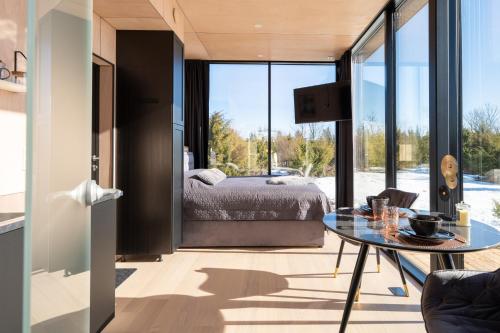 um quarto com uma cama e uma mesa de vidro em Juniper Lux Minivilla Jacuzzi & Sauna 