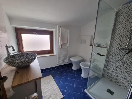 baño con lavabo y aseo y ventana en La casetta in montagna, en Torricella Peligna