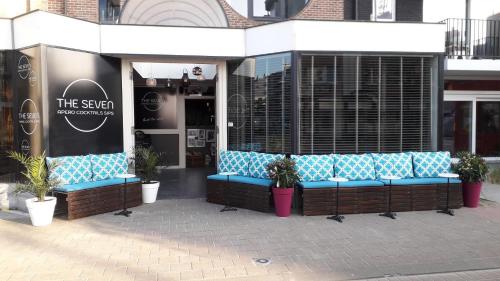 a group of blue benches in front of a store at Bed aan zee Kabine7 in Koksijde