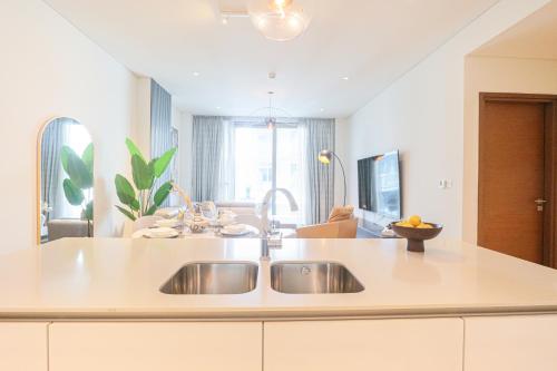 a kitchen with a sink and a living room at HiGuests - Charming Retreat in CityWalk With Balcony and Pool in Dubai