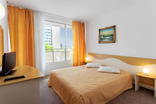 ein Hotelzimmer mit einem Bett und einem Fenster in der Unterkunft Hotel AquaPark Balada Saturn - ULTRA ALL INCLUSIVE in Mangalia