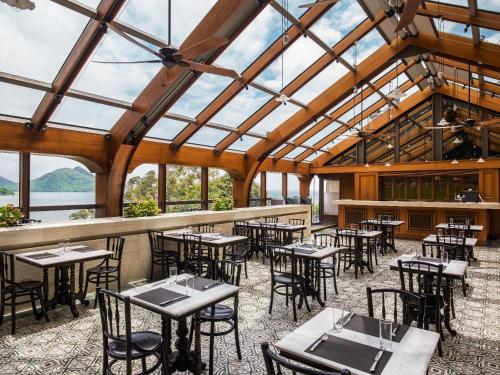 a dining room with tables and chairs and windows at Tai O Heritage Hotel in Hong Kong