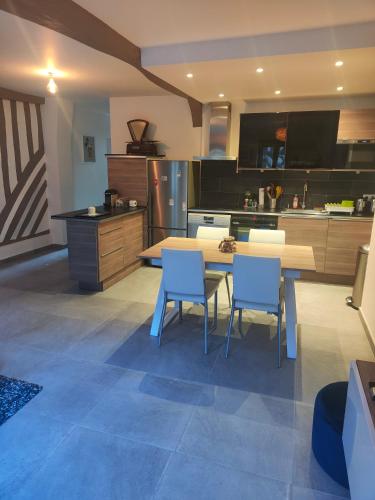 - une cuisine avec une table et des chaises bleues dans la chambre dans l'établissement L appart de la place Ste Catherine, à Honfleur
