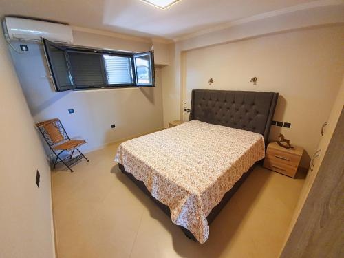 una camera con letto, finestra e sedia di George's Apartment a Città di Lefkada