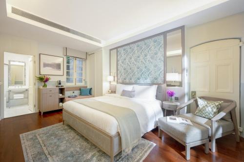 um quarto com uma cama grande e uma cadeira em Tai O Heritage Hotel em Hong Kong